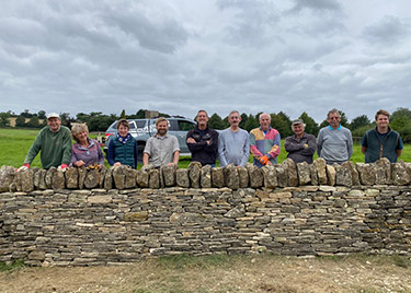 Group stadding behind wall after building it